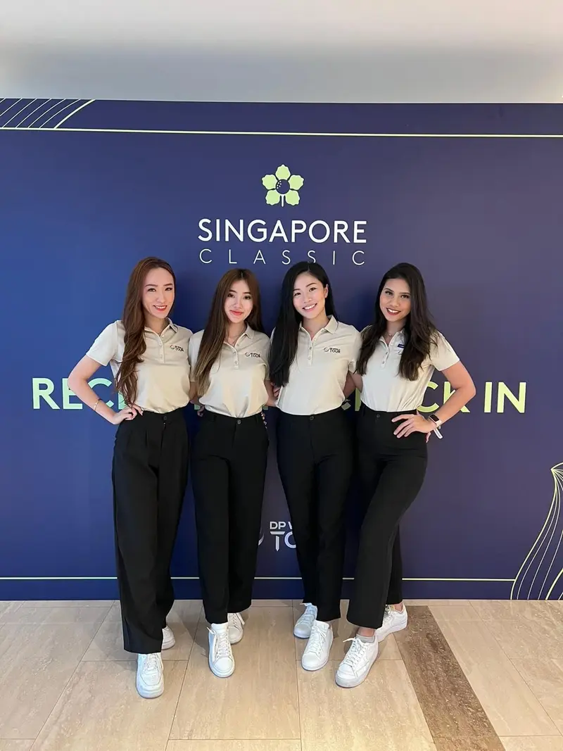 Four event hostesses in matching polo shirts at a tournament check-in backdrop