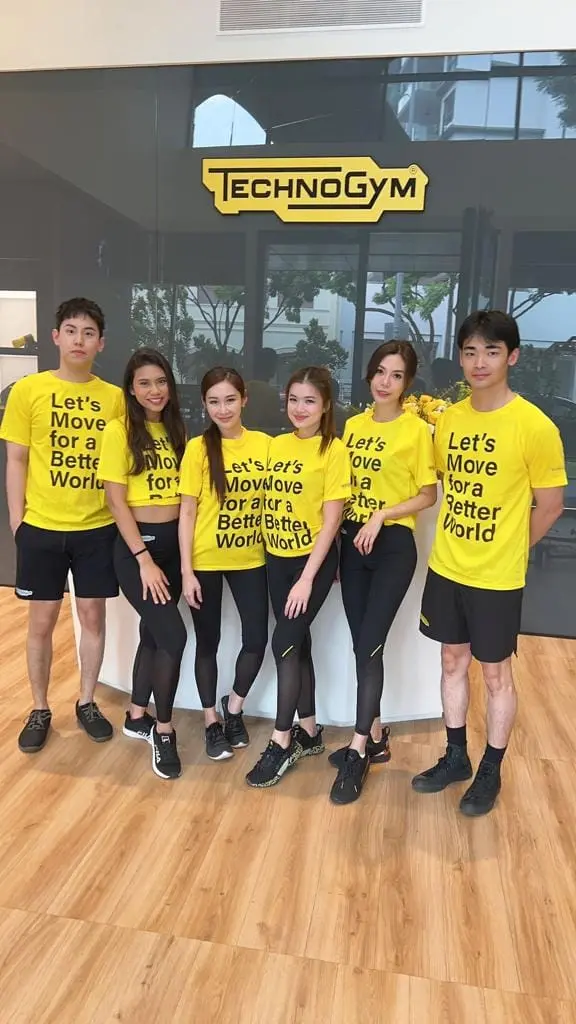 Team of promotional staff in matching yellow T-shirts at a fitness showroom launch